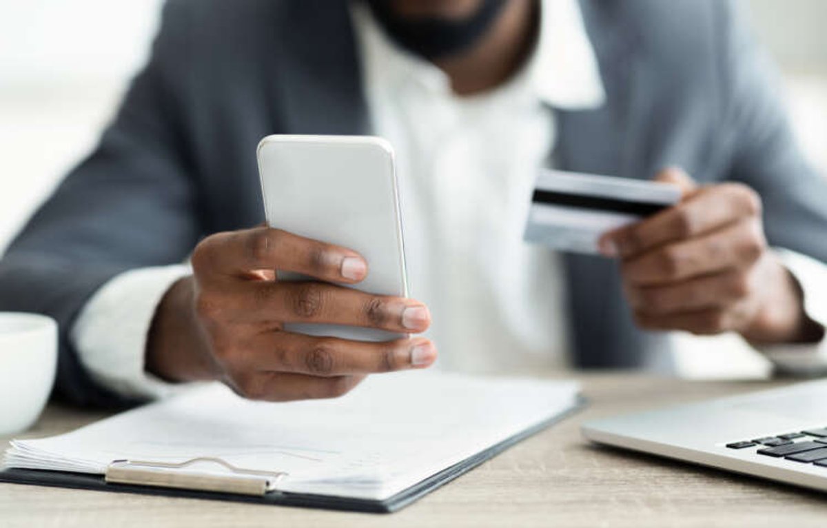 Dark-skinned man using online banking for account-to-account payments - Global Banking & Finance Review