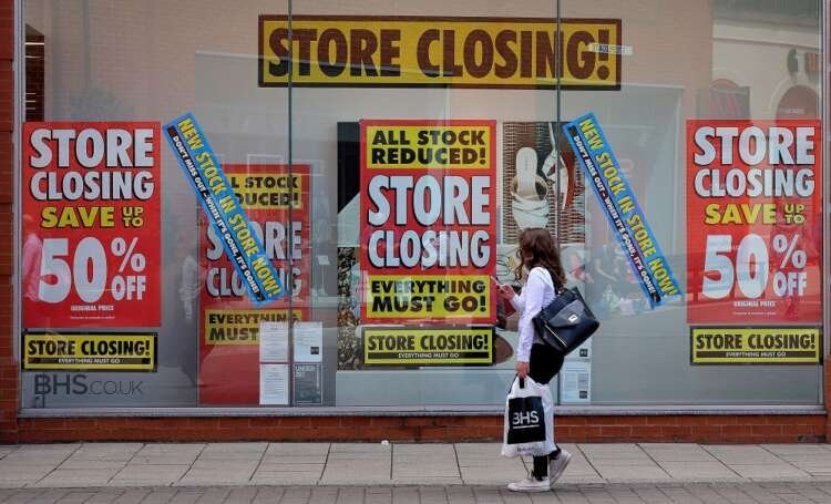 FILE PHOTO: A pedestrian walks past a British Home Stores branch in Chesterfield