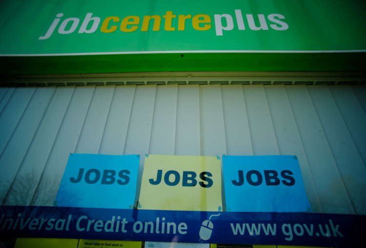 Adverts for jobs are seen in the window of a Jobcentre Plus in Manchester