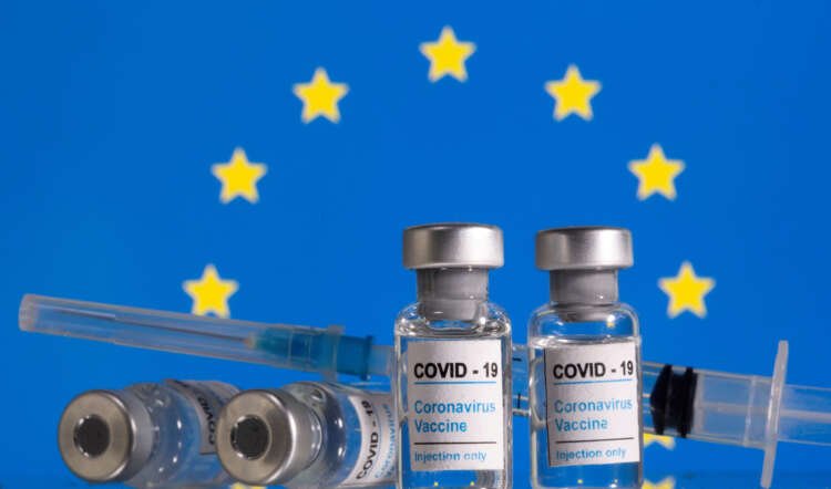 Vials of COVID-19 vaccine and syringes in front of the EU flag - Global Banking & Finance Review
