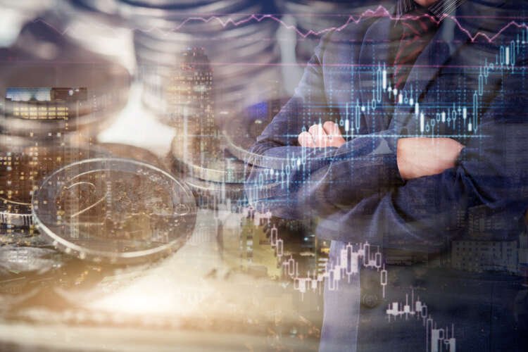 Businessman analyzing financial data with stacks of coins, symbolizing cost savings during economic downturn - Global Banking & Finance Review