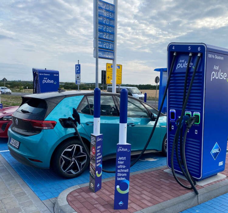An electric car charging at a station, highlighting Germany's EV infrastructure growth - Global Banking & Finance Review