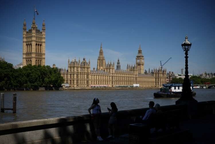People walk by the Houses of Parliament in London during UK prime minister contest - Global Banking & Finance Review