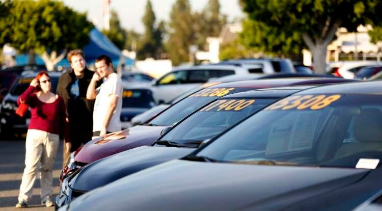 FILE PHOTO: People look at vehicles for sale on the lot at AutoNation dealership in Cerritos