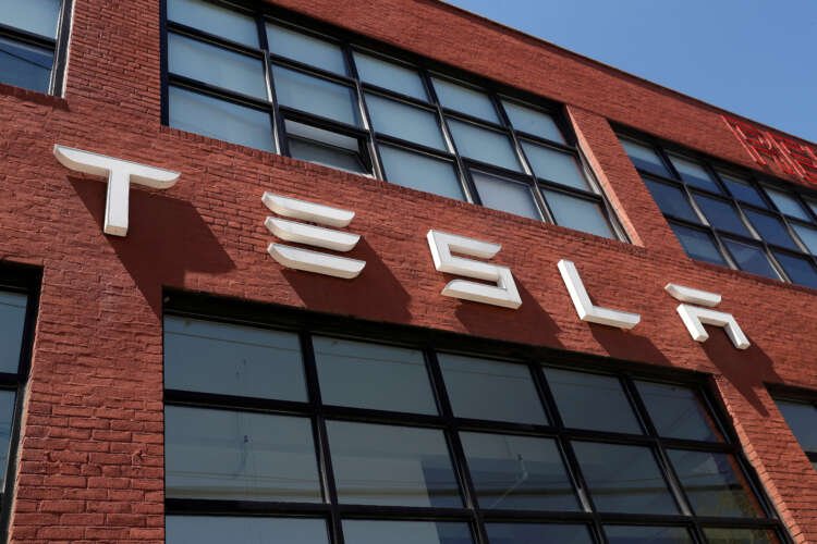 Tesla dealership with logo, reflecting stock drop concerns amid demand issues - Global Banking & Finance Review