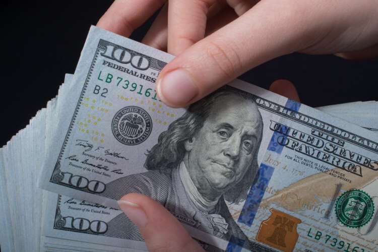 Hand holding American dollar symbolizing inflation concerns in 2023 - Global Banking & Finance Review