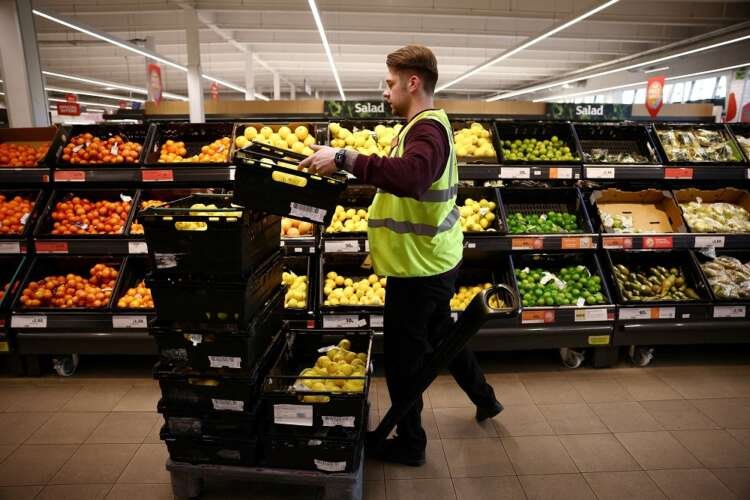 Sainsbury's employee arranging groceries amid UK's cost of living crisis - Global Banking & Finance Review