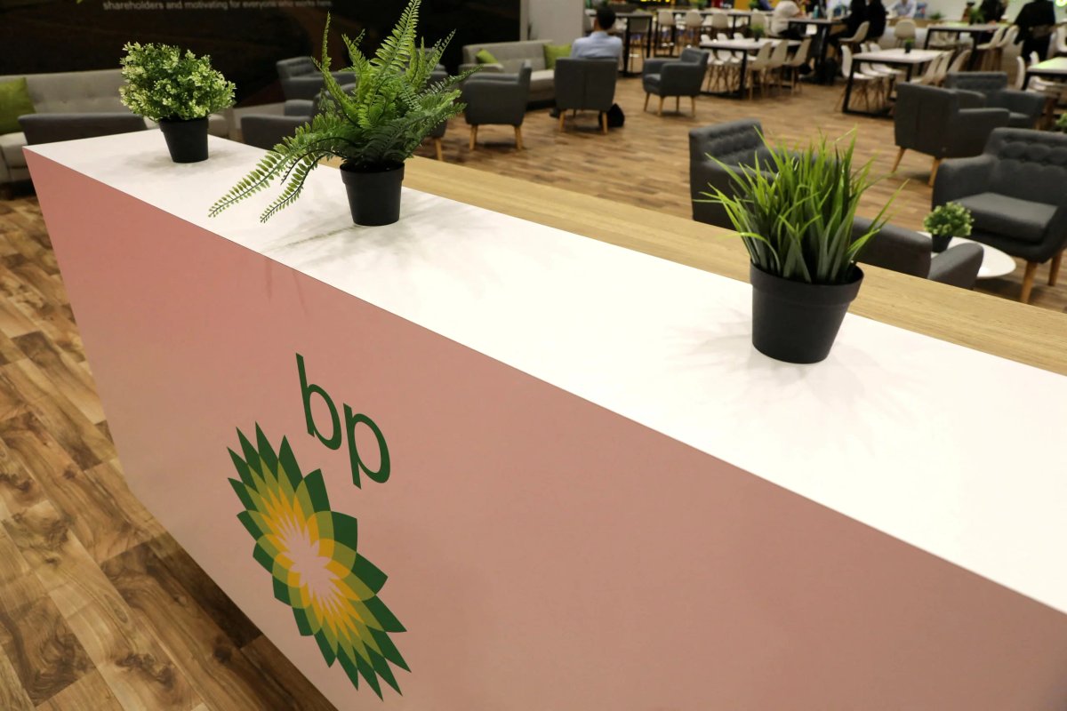 BP logo with a backdrop of oil rigs and wind turbines - Global Banking & Finance Review
