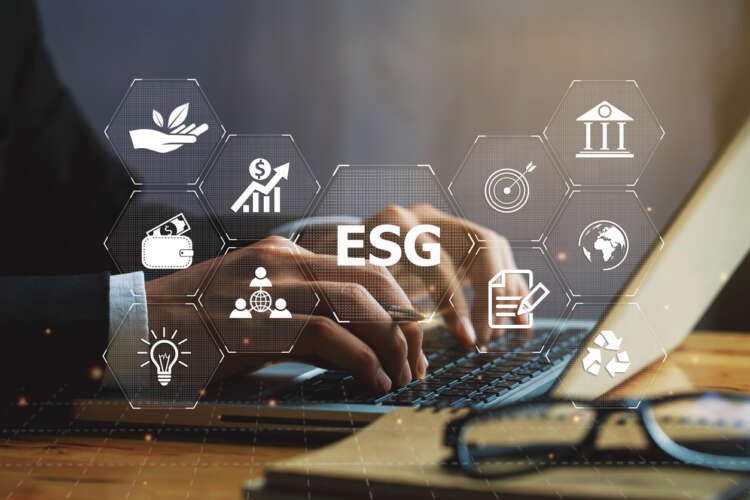 Businessman using laptop displaying ESG icon, symbolizing technology's role in governance - Global Banking & Finance Review