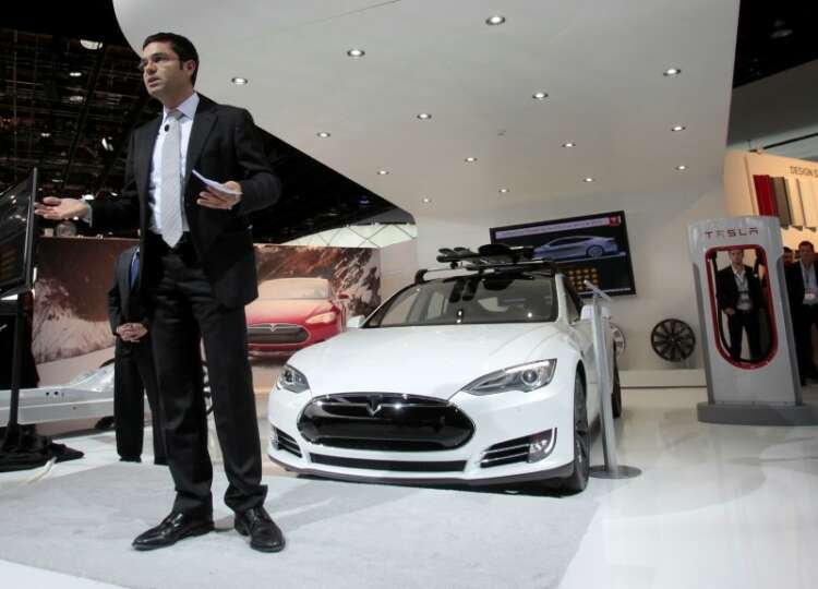 FILE PHOTO: Tesla’s Guillen speaks in front of a Tesla S during the press preview day of the North American International Auto Show in Detroit