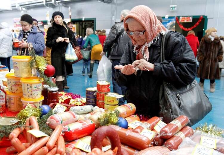 Woman counts cash at a market, reflecting Russia's rising consumer prices - Global Banking & Finance Review