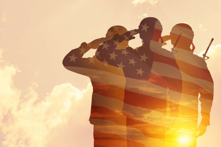 Silhouette of soldiers against a sunset, symbolizing veterans' struggles with VA benefits - Global Banking & Finance Review