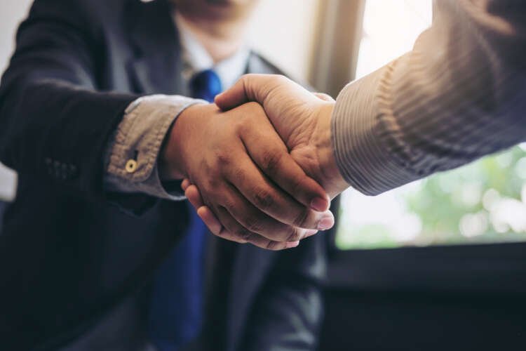 Two business executives shaking hands to signify Cavai's new CEO appointment - Global Banking & Finance Review