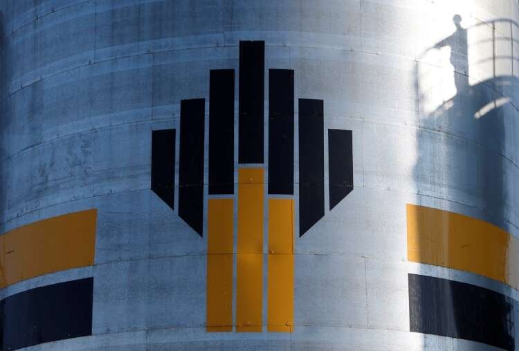 Shadow of worker is seen next to logo of Russia’s Rosneft oil company at central processing facility of Rosneft-owned Priobskoye oil field outside Nefteyugansk