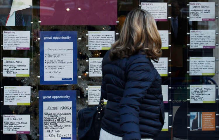 A woman walks past a recruitment center in London, highlighting UK employment trends - Global Banking & Finance Review
