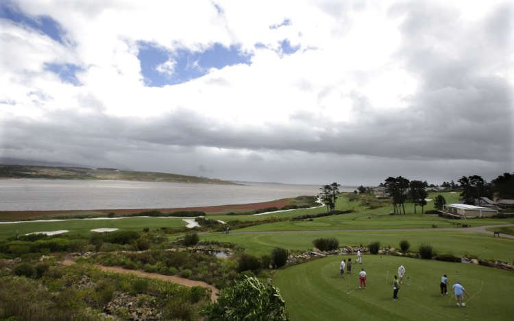 Golfers on a course in Cape Town amidst South Africa's housing crisis - Global Banking & Finance Review