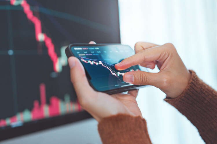 Woman checking Bitcoin price chart on smartphone, reflecting mobile banking trends - Global Banking & Finance Review