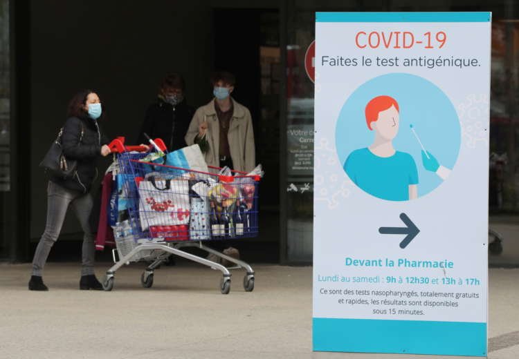 A COVID-19 tests sign is seen near a Carrefour Hypermarket store in Nice
