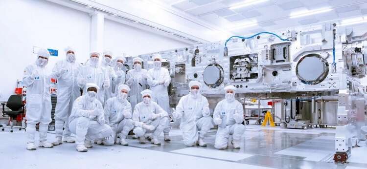 ASML employees stand before a large lithography machine, crucial for semiconductor manufacturing - Global Banking & Finance Review