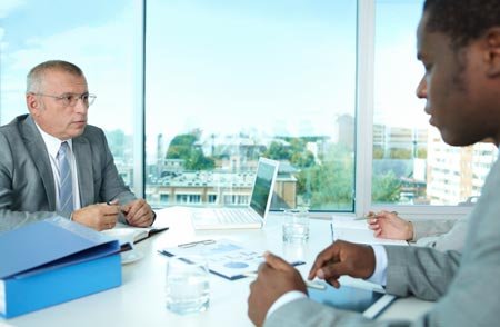 Elderly individuals discussing finance strategies to avoid scams - Global Banking & Finance Review