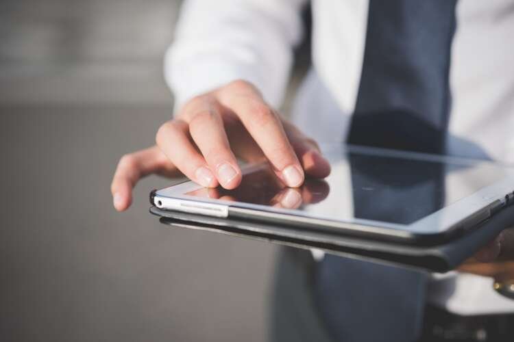 Businessman using a tablet outdoors, symbolizing AI innovation in finance - Global Banking & Finance Review