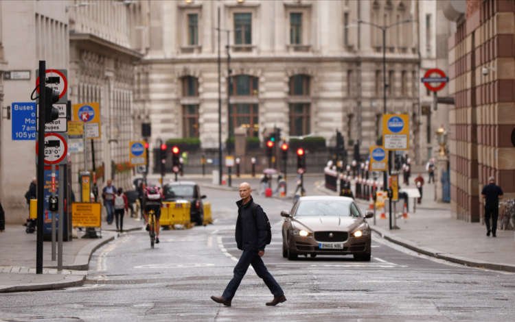 A man crosses the road in London's financial district during COVID-19 - Global Banking & Finance Review