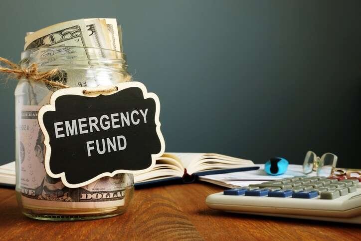 Jar filled with money labeled emergency fund, representing financial planning - Global Banking & Finance Review
