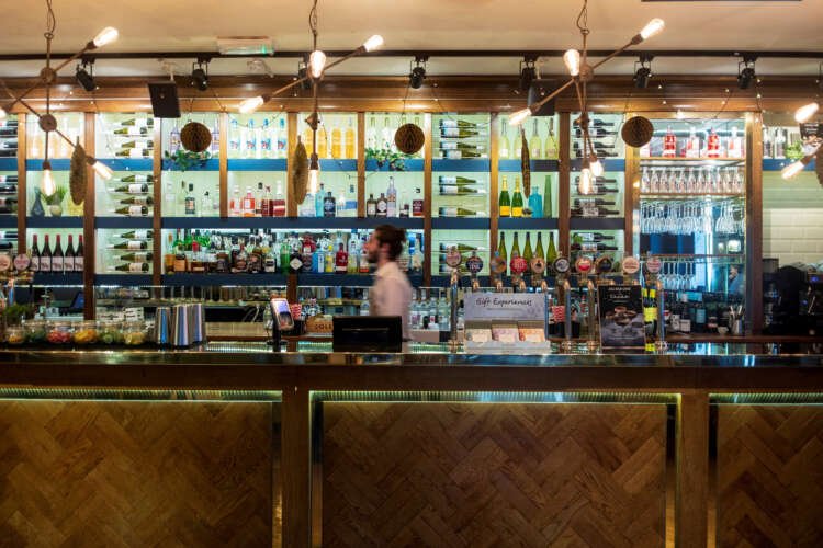 Staff member serving customers at All Bar One, reflecting challenges in UK hospitality - Global Banking & Finance Review