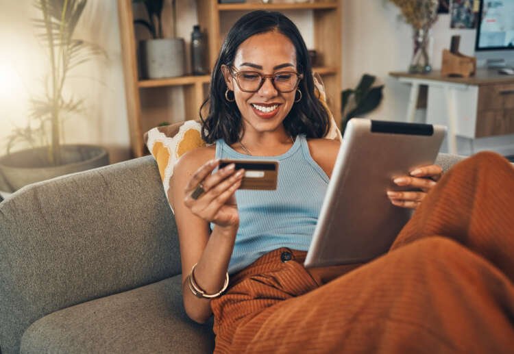 Smiling woman using a digital tablet for online banking - Global Banking & Finance Review