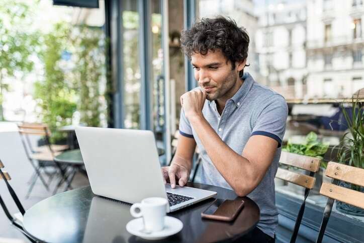 Young entrepreneur working on a laptop, planning a profitable side business - Global Banking & Finance Review