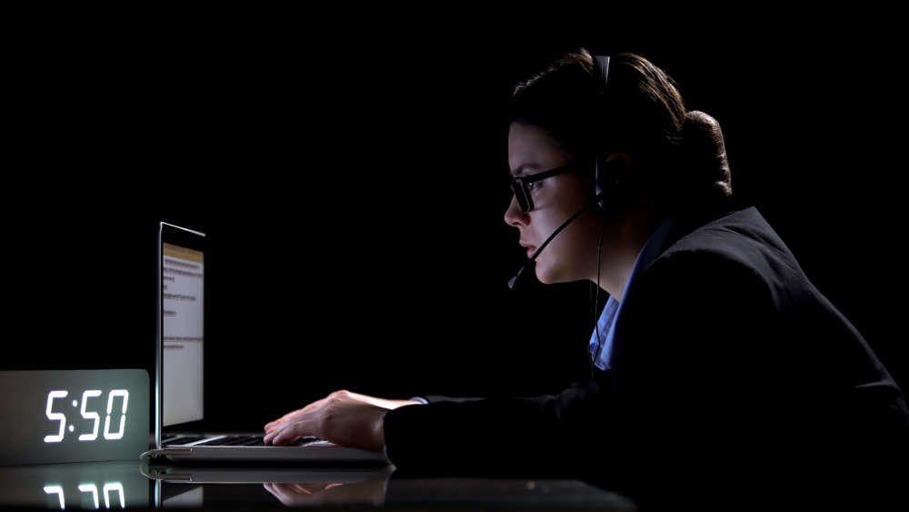 Responsible female call-center employee in headphones during staggered shifts - Global Banking & Finance Review