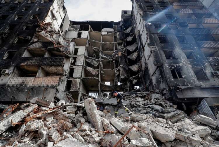 Emergency workers remove debris of a building destroyed in the course of the Ukraine-Russia conflict, in Mariupol