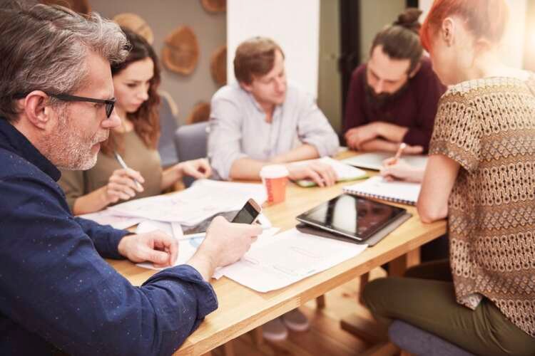 Business professional checking social media during work, reflecting digital transformation challenges - Global Banking & Finance Review