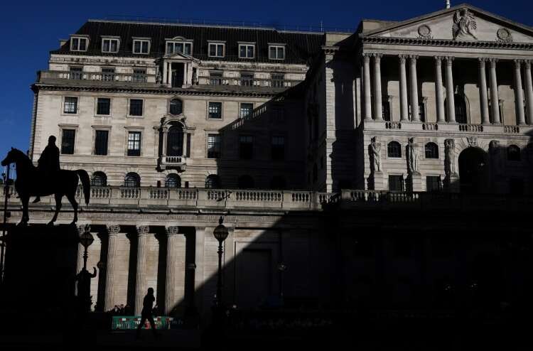 Person walking outside the Bank of England during interest rate hikes amid banking turmoil - Global Banking & Finance Review