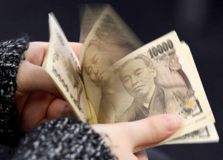 Woman counting Japanese 10,000 yen notes, reflecting yen pressure amid policy decisions - Global Banking & Finance Review