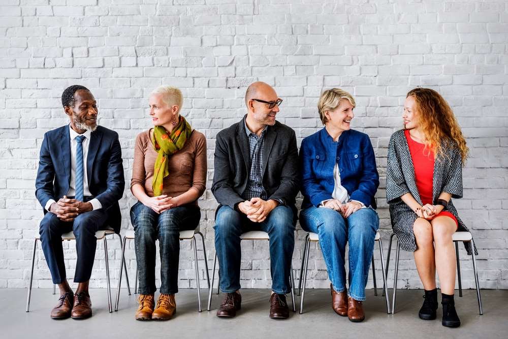 Diverse group of professionals discussing hiring practices in finance - Global Banking & Finance Review