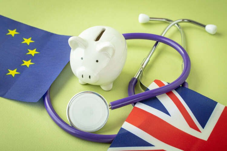 Piggy bank and stethoscope with UK and EU flags, symbolizing IPT in post-Brexit finance - Global Banking & Finance Review
