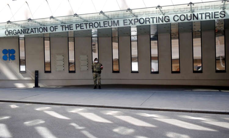 Austrian army member beside the OPEC logo, highlighting oil production stability - Global Banking & Finance Review