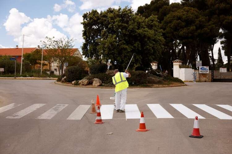 Worker painting crosswalk in Ronda, highlighting Spain's job market amid rising unemployment - Global Banking & Finance Review