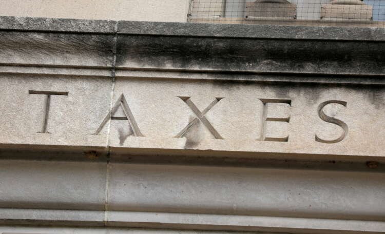 FILE PHOTO: The word “taxes” is seen engraved at the headquarters of the Internal Revenue Service (IRS) in Washington, D.C.