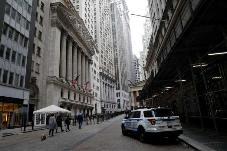 FILE PHOTO: People walk in front of the NYSE in New York