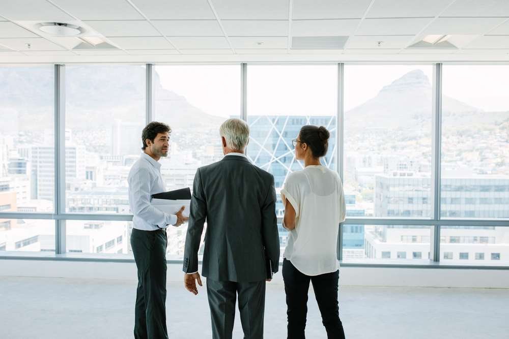 Real estate agents discussing commission earnings in a financial context - Global Banking & Finance Review