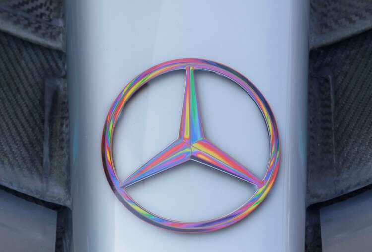 Mercedes-Benz logo with wind turbines representing renewable energy transition - Global Banking & Finance Review