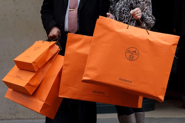 Couple leaving Hermes store with luxury shopping bags - Global Banking & Finance Review