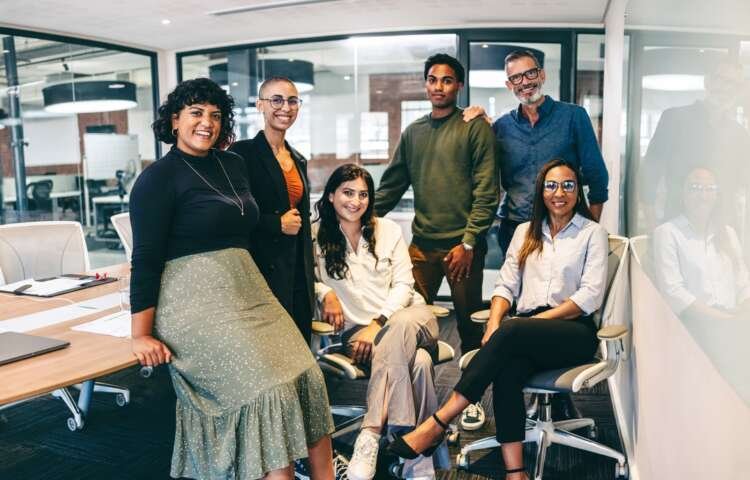 Team of businesspeople smiling at the camera in a boardroom