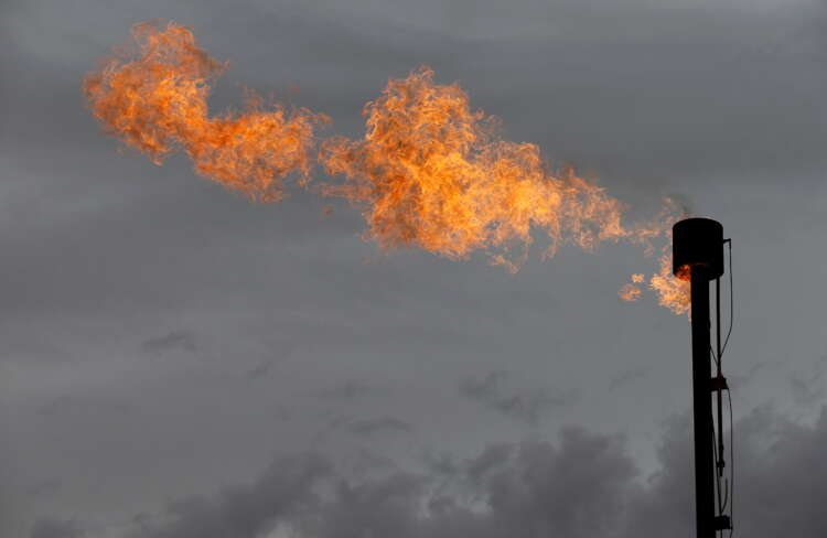 Oil flare burning at a gas plant, symbolizing banks funding oil expansion - Global Banking & Finance Review
