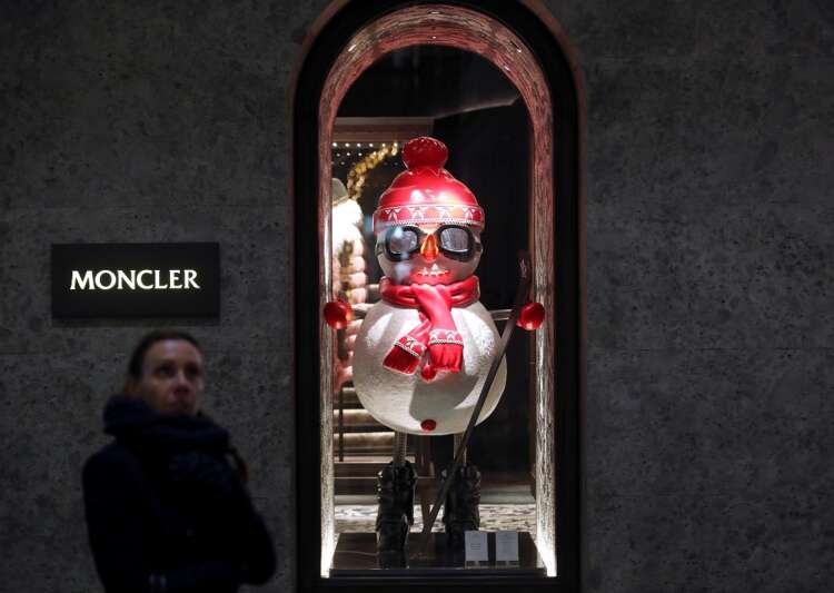 A woman walks past Moncler’s flagship store in Montenapoleone street downtown Milan