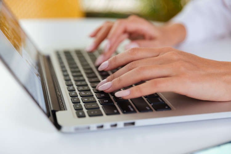 Hands of businesswoman working and typing on laptop