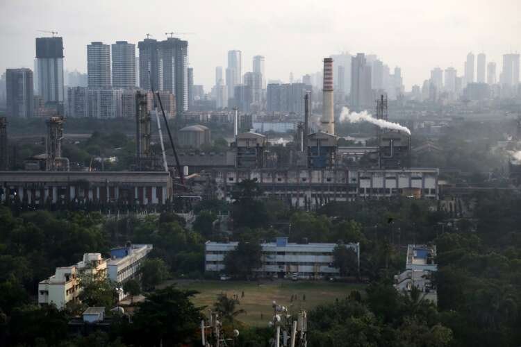 Children play near smoke-emitting chimneys of a chemical plant, highlighting global manufacturing impacts - Global Banking & Finance Review