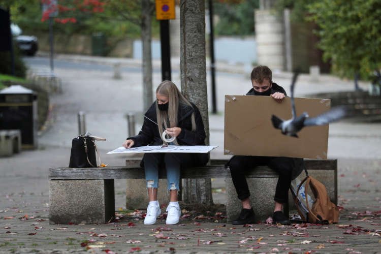 FILE PHOTO: Two Newcastle University students seen drawing at Quayside in Newcastle, Britain